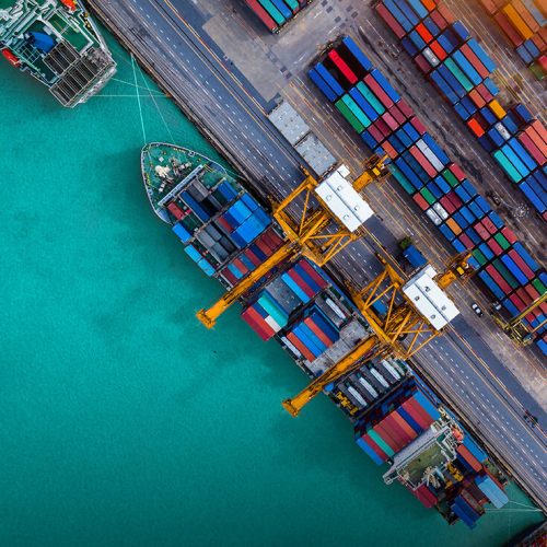 Logistics and transportation of Container Cargo ship and Cargo plane with working crane bridge in shipyard at sunrise, logistic import export and transport industry background